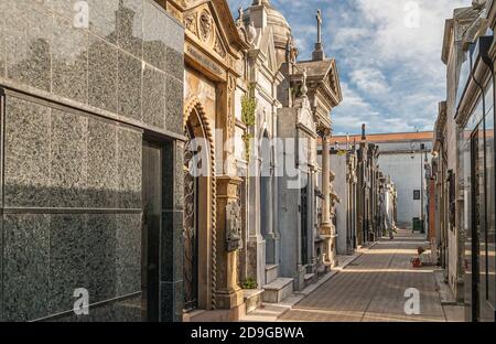 Buenos Aires, Argentiana - 19. Dezember 2008: Friedhof La Recoleta. Gasse zwischen monumentalen Mausoleen in verschiedenen Farben und metarials unter blau cl Stockfoto