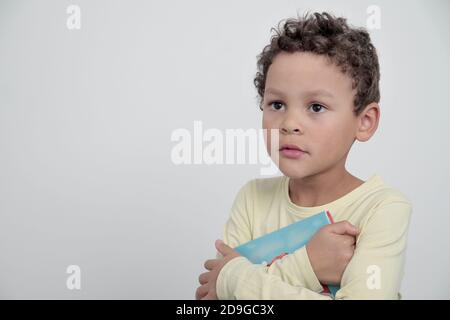 Junge mit Schulbuch zurück zur Schule auf weiß Hintergrund mit grauem Hintergrund Stock Foto Stockfoto