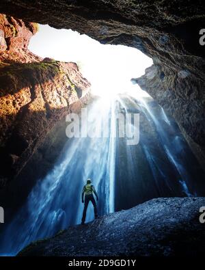 Mann in der Höhle in der Nähe des Gljufrabui Wasserfalls, Island, Europa. Landschaftsfotografie Stockfoto