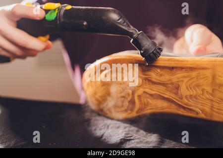 Waschen der schmutzigen Reinigung der Schuhe mit einem Dampfreiniger. Stockfoto