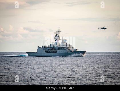 Die Royal Australian Navy Anzac-Klasse Fregatte HMAS Ballarat führt Division Taktiken mit der US Navy während der integrierten operativen Ausbildung 27. Oktober 2020 im Südchinesischen Meer. Stockfoto