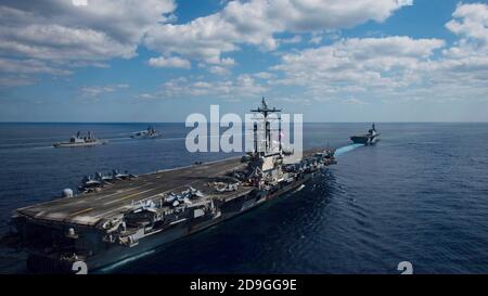 Die US Navy nukleare Flugzeugträger USS Ronald Reagan schließt sich Schiffen der Japan Maritime Self-Defense Force, wie sie in Formation während der Übung Keen Sword segeln 21 26. Oktober 2020 in der philippinischen See. Stockfoto