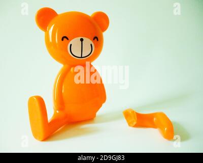 Orange Bär Spielzeug mit einem gebrochenen Bein isoliert auf weiß Hintergrund Stockfoto
