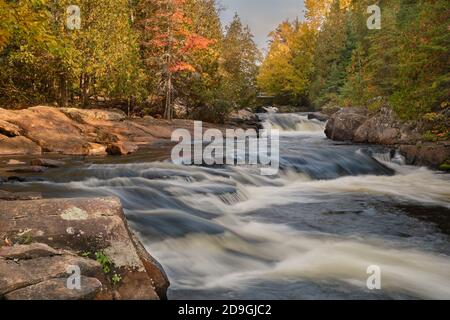 Umgeben von Granitfelsen stürzt das Wasser im Herbst bei den Ritchie Falls in Haliburton, Ontario, eine Reihe kleiner Wasserfälle hinab. Stockfoto