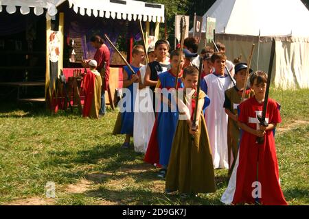 Gruppe von Jungen, die Schwerter in einem Sommerlager im mittelalterlichen Stil halten Stockfoto