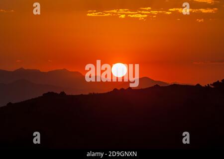 Feuriger Sonnenuntergang über den Bergen Stockfoto