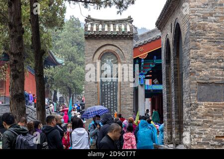 Schwärme von Besuchern, in Regenmäntel verschiedener Farben gekleidet, besuchen Shaolin Kloster, auch bekannt als der Shaolin Tempel, die und seine Pagode Wald wer Stockfoto