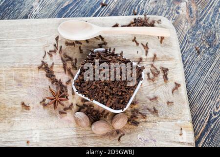 Gewürznelken auf einem alten Holztisch verstreut Stockfoto