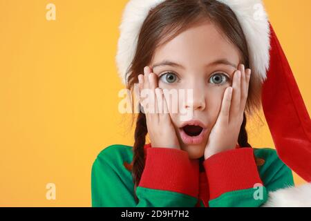 Überrascht kleines Mädchen gekleidet als Elfe auf farbigem Hintergrund Stockfoto