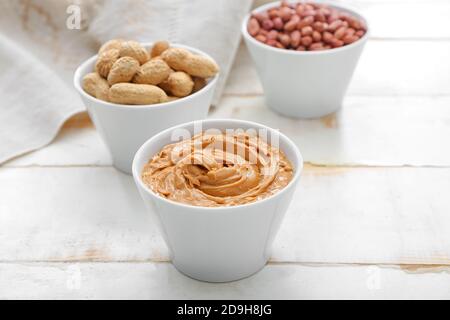 Schüsseln mit leckeren Erdnüssen und Butter auf dem Tisch Stockfoto