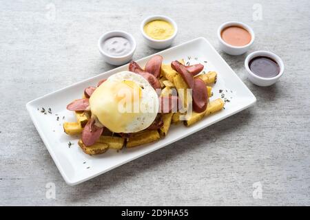 Salchipapas ist ein Fast-Food-Gericht aus Lateinamerika, in den Straßen von Lima, Peru und Kolumbien, Bolivien und Ecuador verkauft. Stockfoto