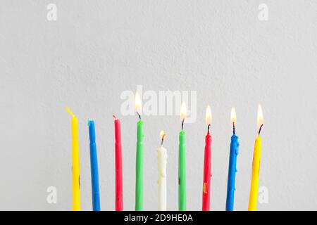 Glühende Kerzen für Hanukkah auf weißem Hintergrund Stockfoto