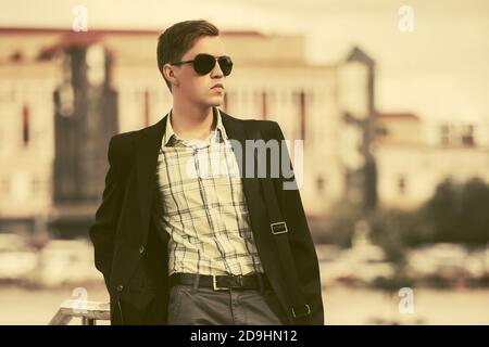 Junge gut aussehende Geschäftsmann auf Stadt Straße stilvolle Mode männlich Modell in schwarzem Blazer und Sonnenbrille Stockfoto