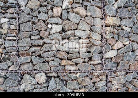 Nahaufnahme von Gabion, Zaun aus Steinen in Metallgeflecht für den Einsatz im Tiefbau, Straßenbau Landschaftsbau. Stockfoto