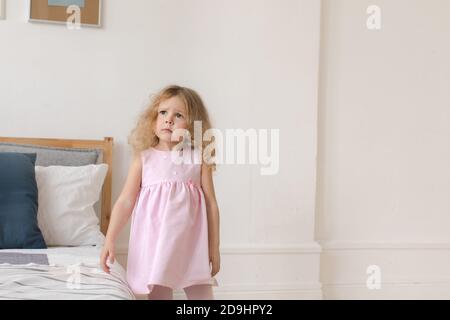 Charming Kind in rosa Kleid zu Hause Stockfoto