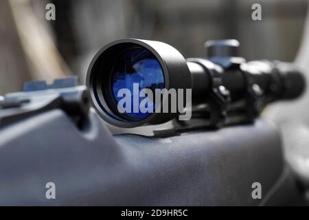 Nahaufnahme der Teleskopsicht mit Reflexion in der Linse montiert auf Gewehr für Scharfschützenschießen Stockfoto