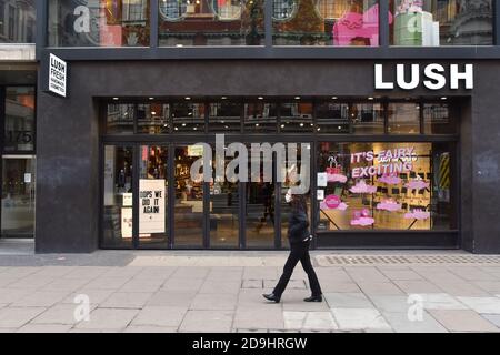 London, Großbritannien. November 2020. Eine Frau, die eine Gesichtsmaske trägt, geht an einem üppigen Laden in der Oxford Street vorbei, der wegen der zweiten Sperre Englands geschlossen ist. Kredit: SOPA Images Limited/Alamy Live Nachrichten Stockfoto