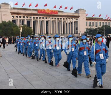 Eine Reihe von Sanitäter gehen auf dem Platz des Himmlischen Friedens und bereiten sich darauf vor, den Ort während des Nationalfeiertags 2020, Peking, China, 7 Oktober, zu reinigen Stockfoto