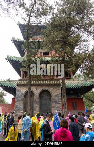 Schwärme von Besuchern, in Regenmäntel verschiedener Farben gekleidet, besuchen Shaolin Kloster, auch bekannt als der Shaolin Tempel, die und seine Pagode Wald wer Stockfoto