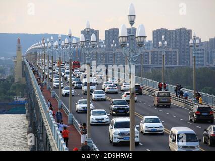 Ein geschäftiger Verkehrsfluss aus verschiedenen Fahrzeugen bewegt sich langsam auf der Nanjing Yangtze River Bridge, eine doppelstockige Straße-Schiene-Fachwerk-Brücke, wie die 2020 Stockfoto