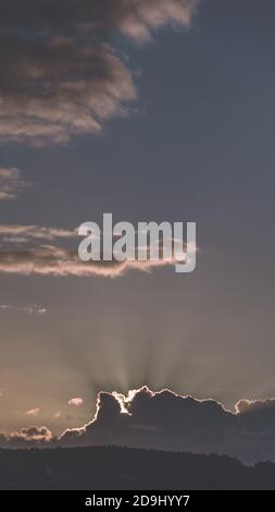 Vertikale Panoramaaufnahme einer wunderschönen, dramatischen Wolkenlandschaft mit Kulisse Sonnenstrahlen Stockfoto