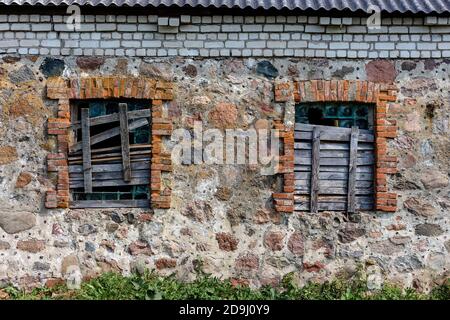 Zwei Fenster in einem alten Gebäude mit Brettern Stockfoto