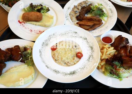 Teller mit verschiedenen Gerichten auf Tablett im Restaurant Stockfoto