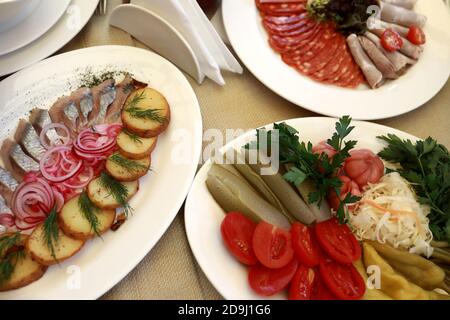 Teller mit verschiedenen Vorspeisen auf dem Tisch im Restaurant Stockfoto