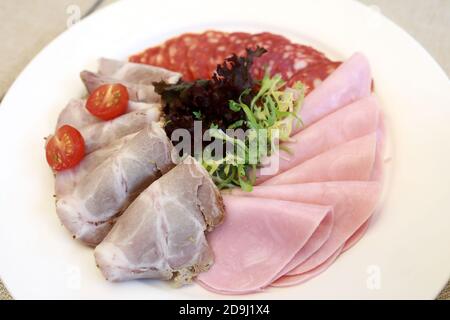 Scheiben verschiedene Fleisch auf weißem Teller im Restaurant Stockfoto