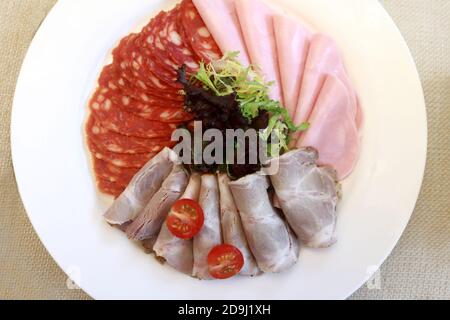 Scheiben verschiedene Fleisch auf Teller im Restaurant Stockfoto