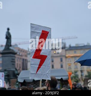 Roter Blitz als Symbol der Frauen Streik Bewegung auf Banner hält von Protestierenden während Anti-Regierung-Demonstration in Krakau, Polen Stockfoto