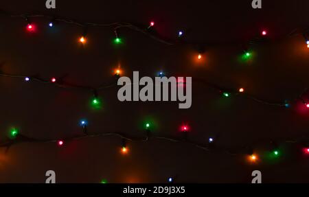 Leuchtende bunte Weihnachtslichter auf schwarzem Hintergrund Stockfoto