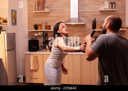 Misshandelte Ehefrau, die nach brutaler Schlägen mit ihrem Mann kämpft. Traumatisiert missbraucht erschrocken geschlagen Frau mit Prellungen leiden Verletzungen von alkoholischen gewalttätigen brutalen betrunkenen Mann bedeckt. Stockfoto