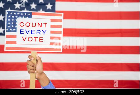 Hände halten Zählen Sie jede Stimme Schild mit US-Flagge als Hintergrund mit Copy Space - Konzept der Wähler Rechte und US-Wahl. Stockfoto