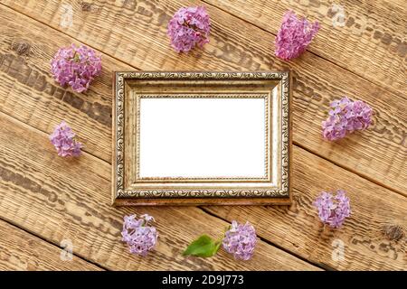 Vintage Fotorahmen mit Kopierraum und Fliederblumen auf alten Holzbrettern. Draufsicht. Stockfoto