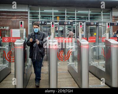 Moskau. Russland. 29. Oktober 2020. Passagiere passieren automatische Drehkreuze an der Moskauer U-Bahn-Station. Auf den Gesichtern der Menschen, Schutzmasken Stockfoto