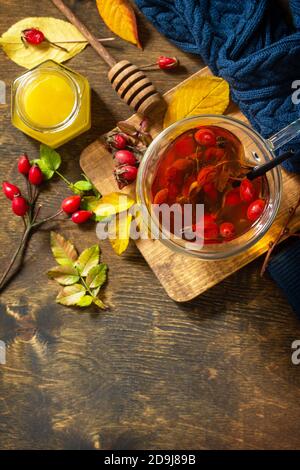Gesundes Wintervitamingetränk. Heißer Hagebuttentee mit Honig und getrockneten Früchten auf einer Holzplatte. Draufsicht flach lagen Hintergrund. Speicherplatz kopieren. Stockfoto