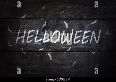 Halloween weiße Buchstaben auf schwarzem Holz, verkohlten Hintergrund mit Fledermäusen Stockfoto