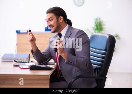 Männlicher Mitarbeiter, der Flash-Laufwerk in den Laptop einsteckt Stockfoto