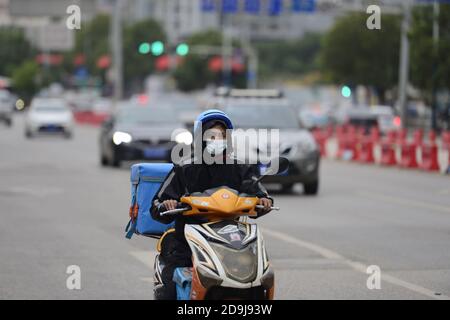 Bürger auf der Straße tragen Wintermantel als die Temperatur stark sinkt, wie die Saison ändert, Kunming Stadt, Südwesten Chinas¯s Yunnan Provinz, 19 O Stockfoto