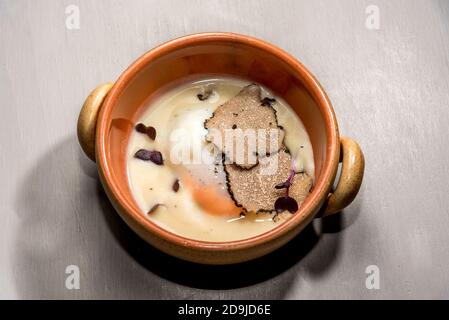 Gebackenes Ei und ​​fontina-Käsefondue mit geschnittenen Trüffeln cocotte Stockfoto