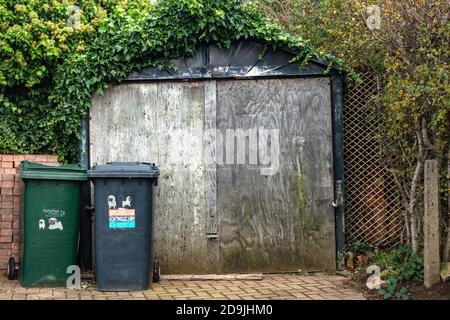 Sehr alte, selbstgemachte bewachsene Garage außerhalb eines Hauses in sheffield, Stockfoto