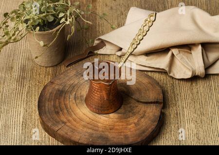 Ein türkischer Kaffee auf einer Baumstammscheibe und weiter Ein Holztisch Stockfoto