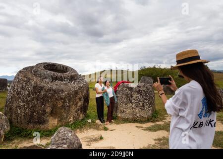 (201106) -- VIENTIANE, 6. November 2020 (Xinhua) -- Touristen posieren für Fotos in der Ebene von Jars, einer megalithischen archäologischen Landschaft in der Provinz Xieng Khuang, Laos, am 3. November 2020. Die Ebene der Jars, die offiziell als Megalithische Jar-Stätten bezeichnet wird, wurde offiziell auf der Liste des Welterbes der Menschheit eingetragen, die am 10. Juli 2019 in Baku, Aserbaidschan, stattfand. The Plain of Jars ist nach den mehr als 2,100 röhrenförmigen megalithischen Steinkrügen benannt, die laut der United Nations Educational, Scientific, in der Eisenzeit für Begräbentäraktiken verwendet wurden Stockfoto