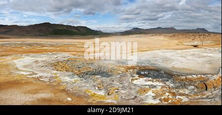 Mudpot im Bereich Geothermie Hverir, Island. Die Gegend um den kochendem Schlamm ist bunt und rissig. Stockfoto