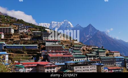 Namche Bazar, Nepal - 11/14/2019: Sherpa Dorf Namche Bazar, Himalaya, die größte Siedlung in der Khumbu Region, unter mächtigen schneebedeckten Bergen. Stockfoto