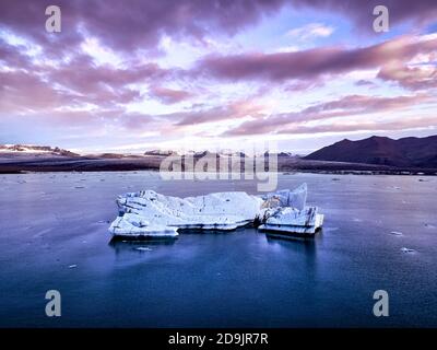 Luftaufnahme der Gletscherlagune in Island während des Sonnenaufgangs. Eisschollen kalbten vom Gletscher. Schmelzendes Eis Stockfoto
