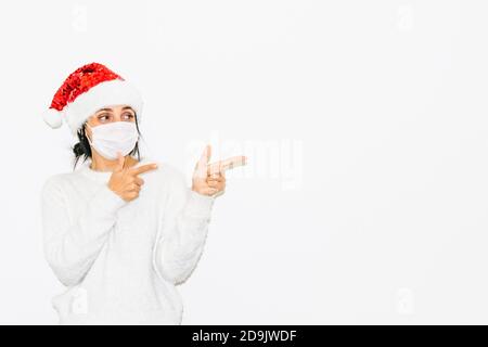 Cute kauätzische Frau in Weihnachten Outfit Punkte Zeigefinger auf der rechten weißen Leerraum. Werbung und Grüße Leerraum Konzept. Stockfoto