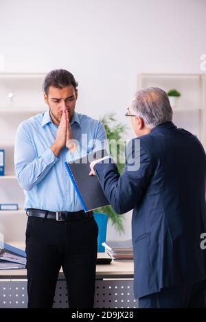 Alter Chef und junge Assistentin im Büro Stockfoto