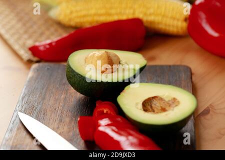 Zwei Hälften Avocado und Paprika auf Holzschnitt Platine Stockfoto